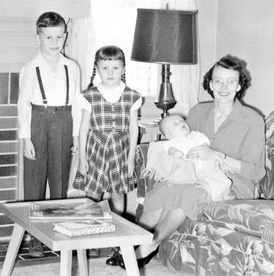 Here we see the arrival of Dave. This photo is in the Wayne Drive house in Mambrin Gardens. There is an issue of Life on the living room table. I am dressed as in the previous (above) picture.