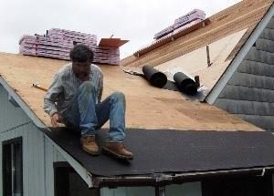 Roofing the back porch. Bill applies the first layer of tar paper.