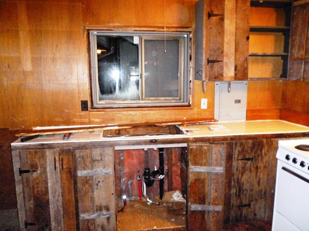The old kitchen in January 2012, with the driftwood cabinet fronts coming off and the tile counter still in place.