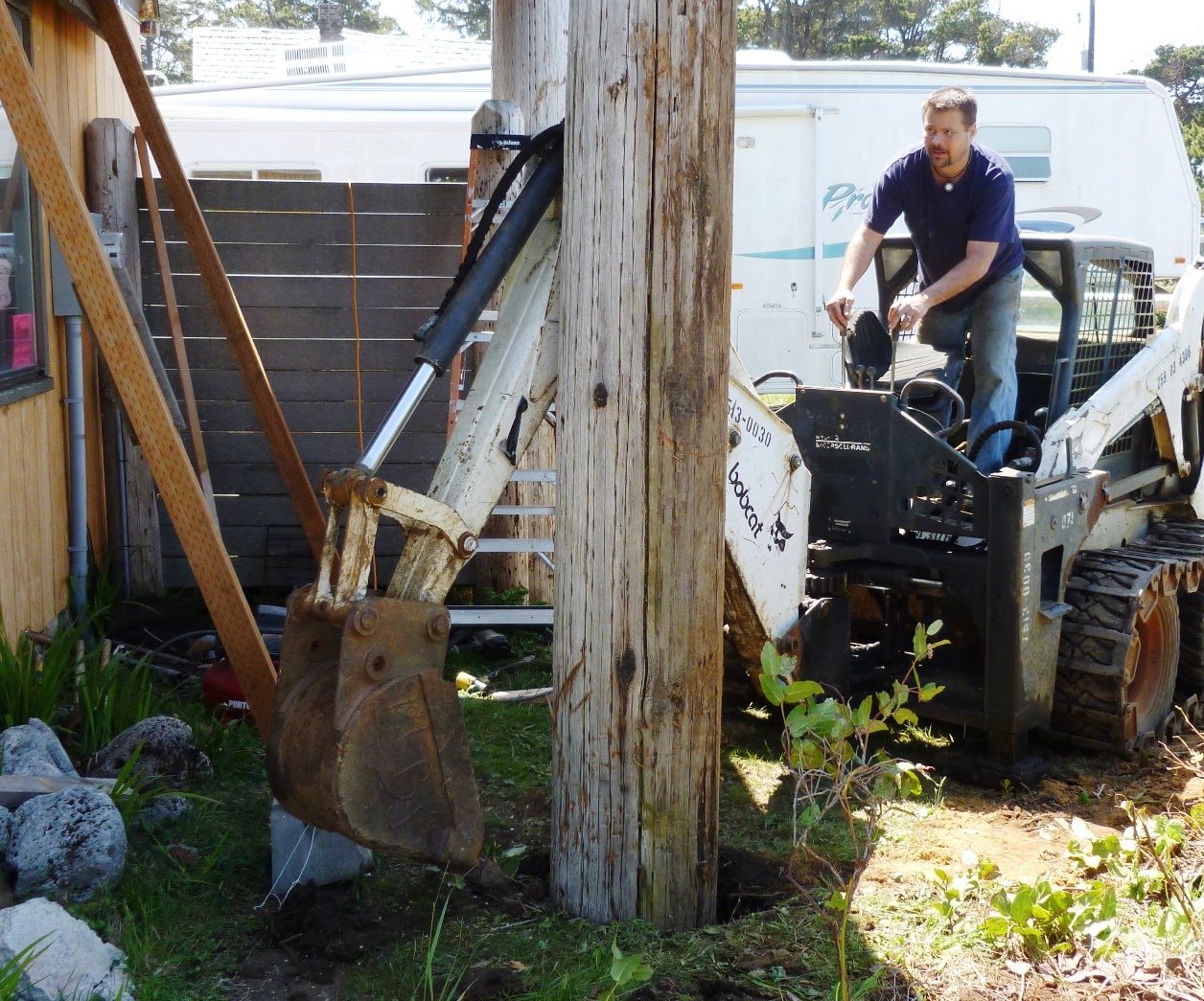 Chris Reiter's Bobcat setting one of the telephone poles that carry the second-floor balcony, 2012.