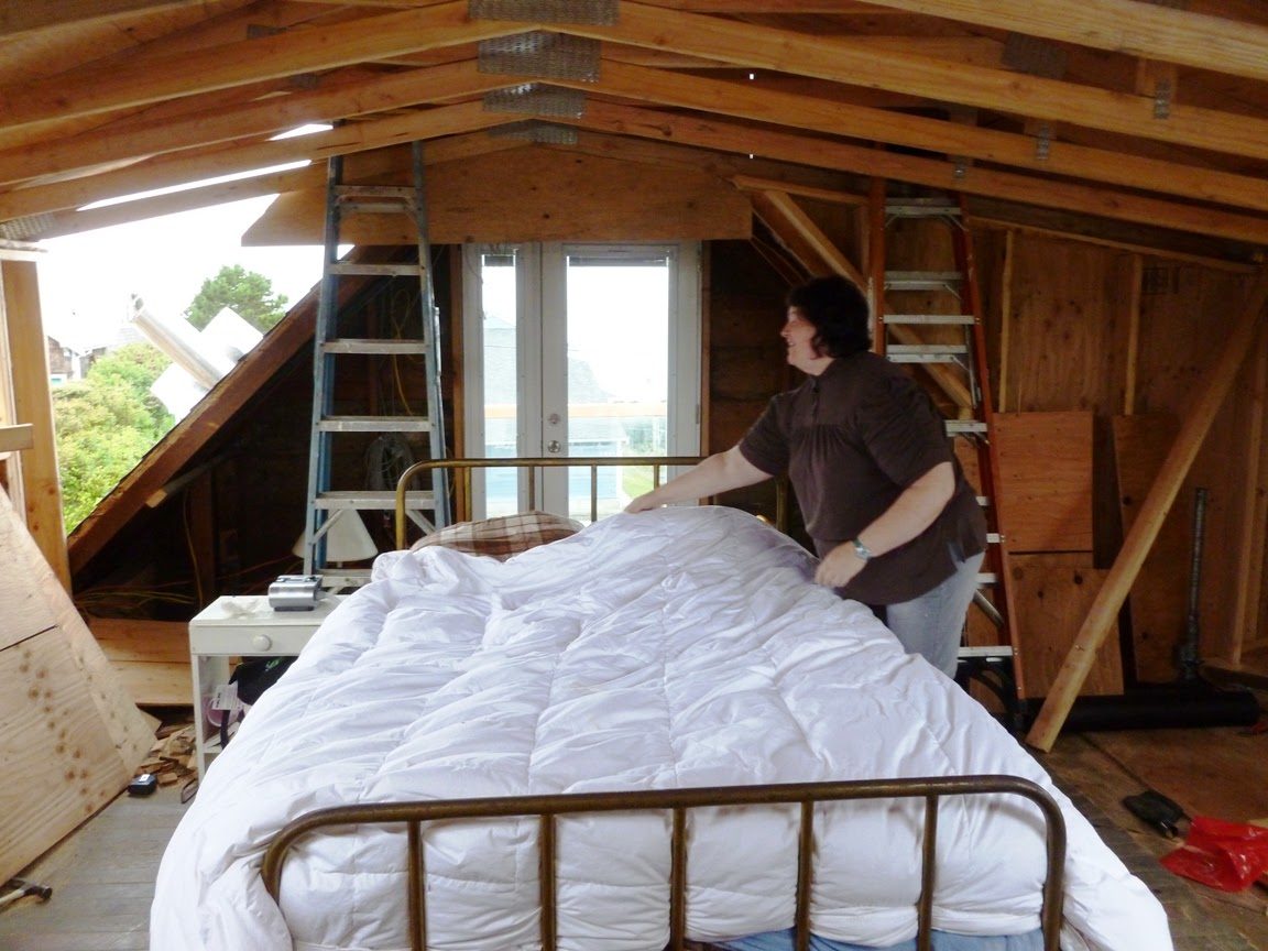 Then: the upstairs in 2012, mid-job. Barb makes a bed while the dormer openings are still being framed.