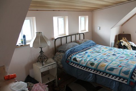 There is a bed on the south side of the upstairs. There is enough headroom to walk from the south to north wall.
