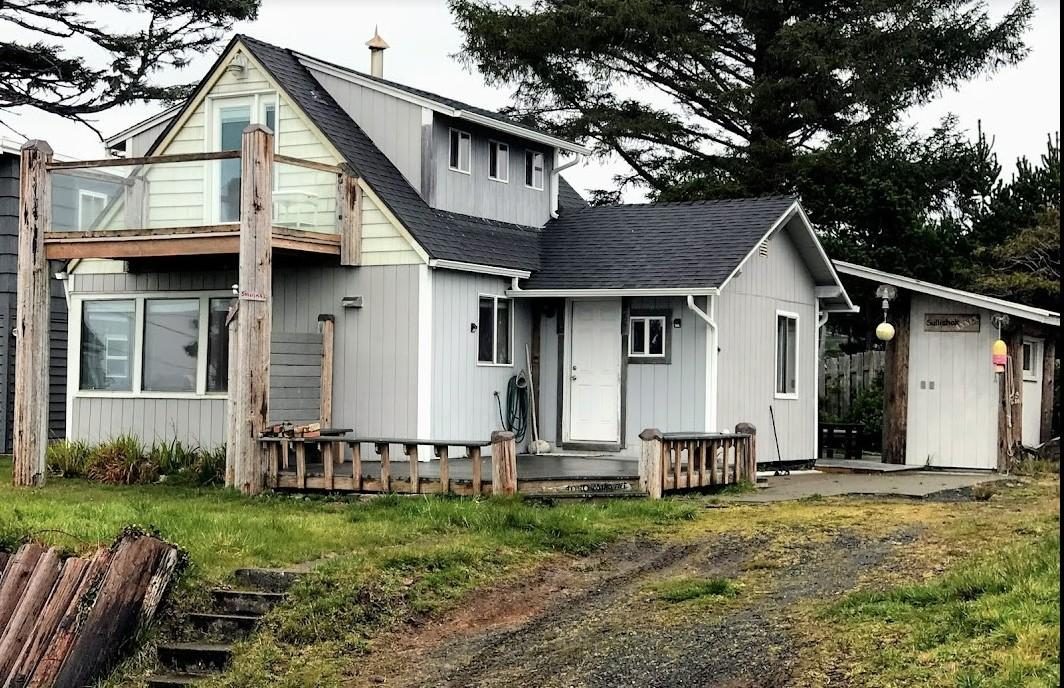 The cabin from Mina Avenue: the second-floor balcony sits on two recycled telephone poles.